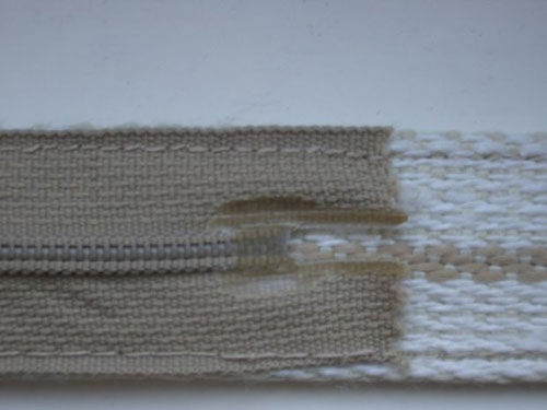 Process the lower edge of the zipper