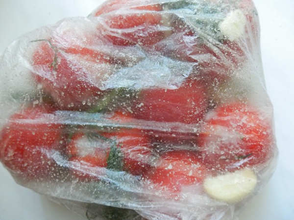 Freshly salted tomatoes in a bag and a saucepan